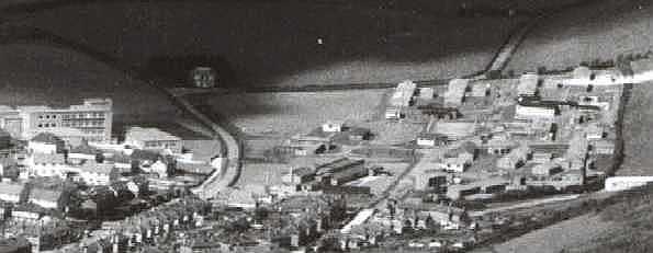 Aerial view: a school and houses to the left and the RAF camp to the right.